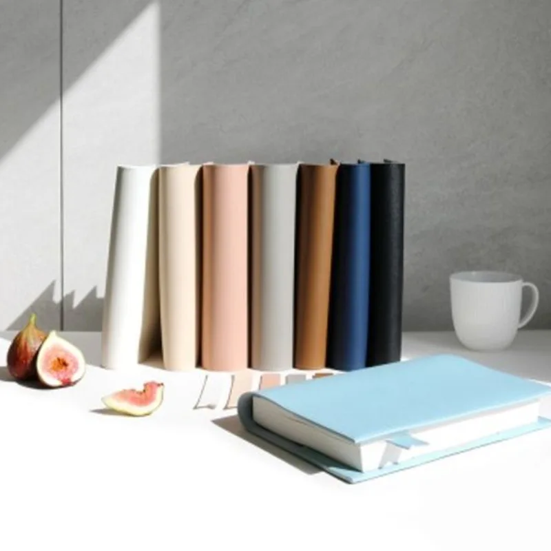 Rangée de couvre-livres lisses aux teintes douces, debout sur une table